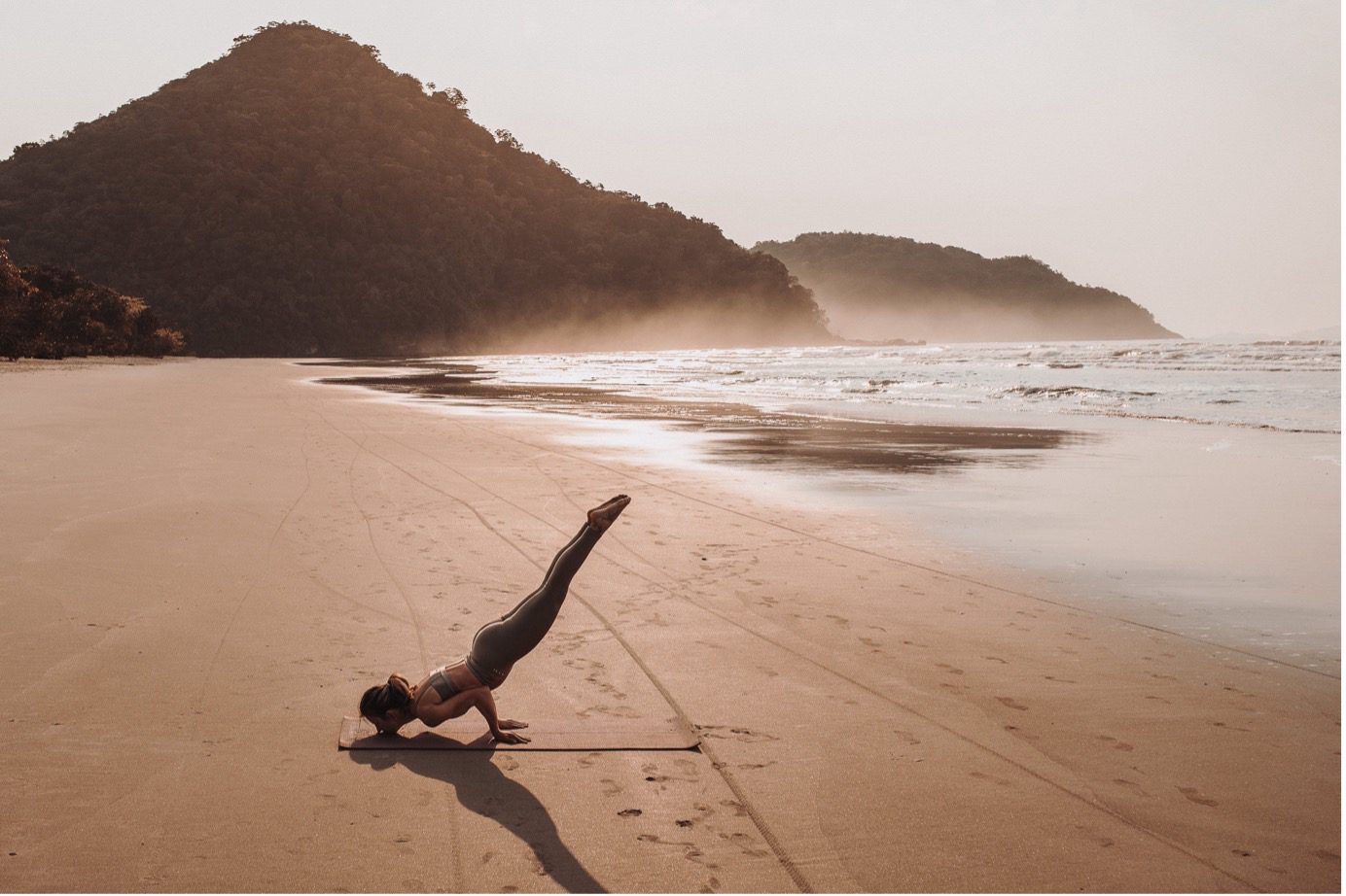 woman doing yoga at the beach