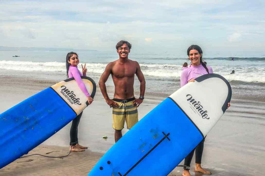 Surf instructor with two surfers at surf camp bali
