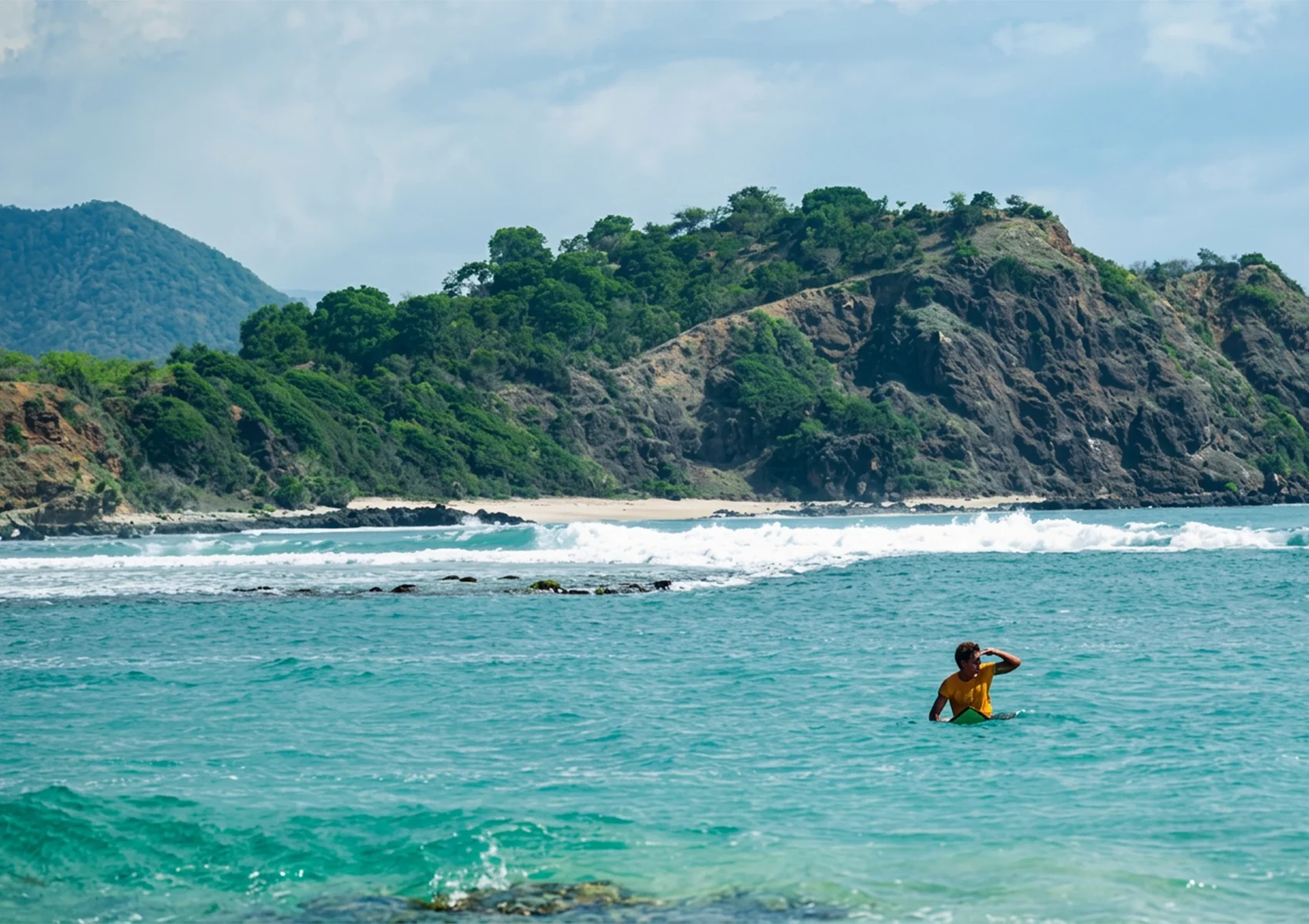 Surfer waiting offshore near Bali reef breaks known for the biggest waves during dry season swells.