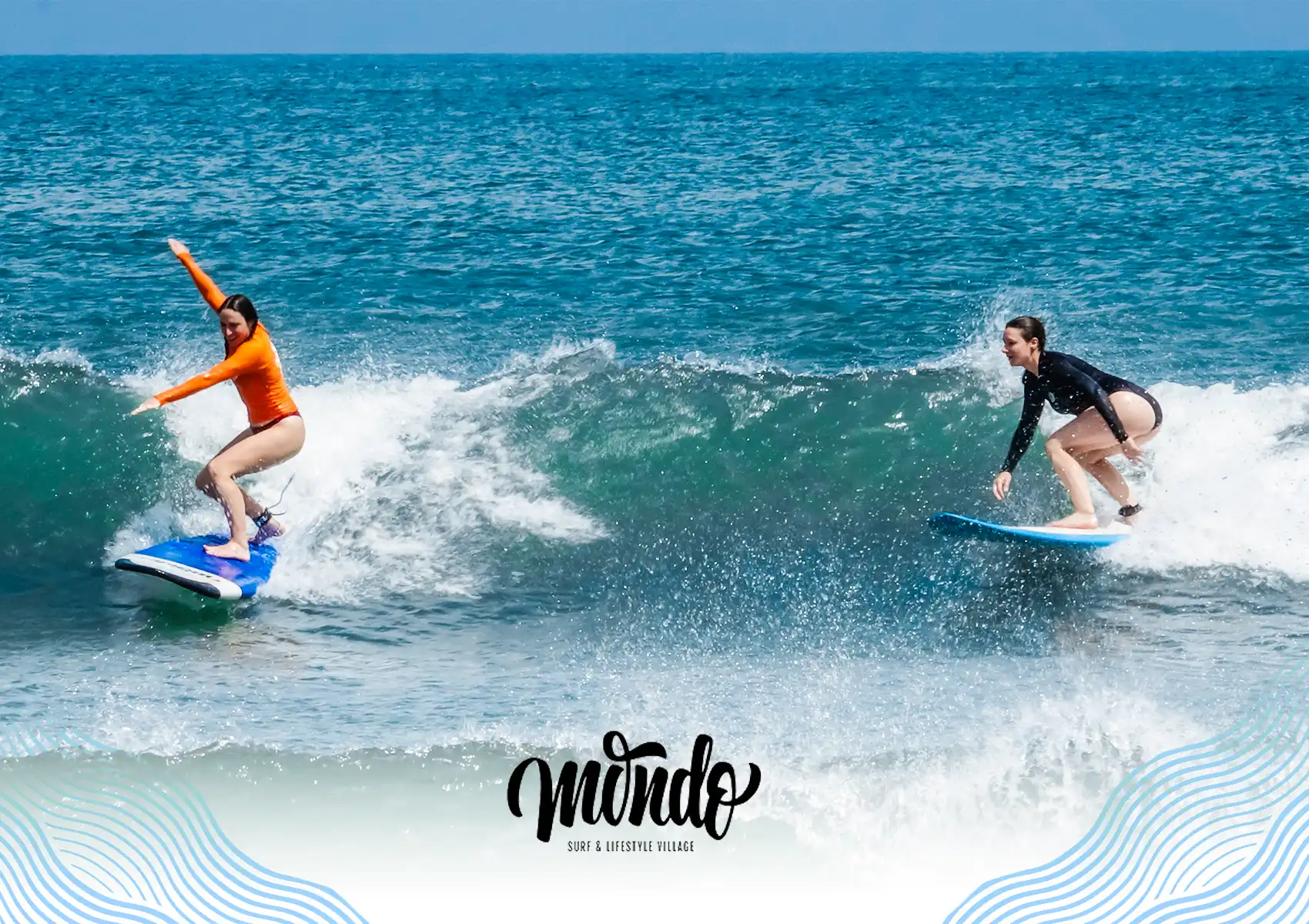 Two female surfers successfully riding a small wave side-by-side in the ocean during a lesson at a surf camp Bali.