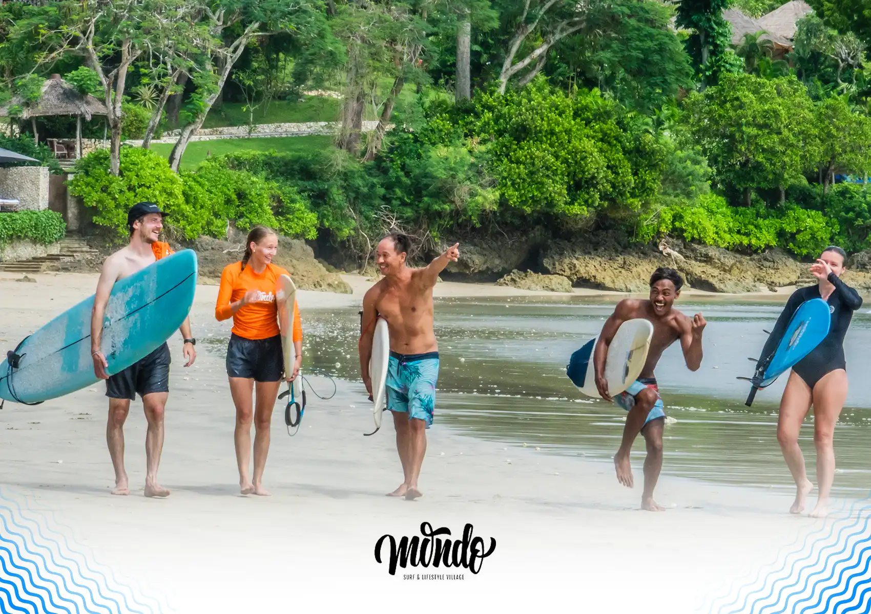 A happy group of surfers laughing and carrying their boards along a beautiful tropical beach after a fun session at a surf camp Bali.