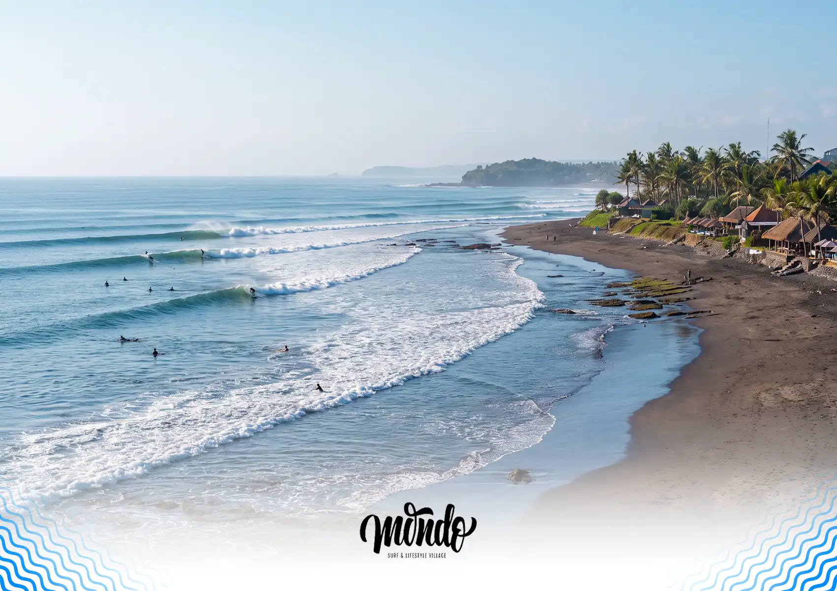 A scenic, elevated view of a coastline featuring surfers riding waves in the ocean next to a beachfront resort with thatched roofs at a surf camp Bali.